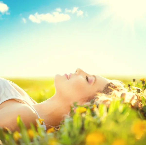 Chica acostada en el campo de verano con flores — Foto de Stock