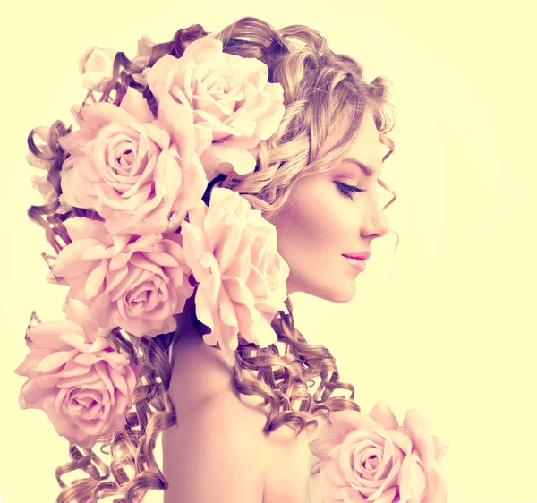 Menina com flores de rosa no penteado — Fotografia de Stock