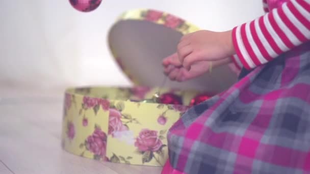Маленька дівчинка прикрашає ялинку — стокове відео