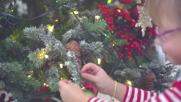 Klein meisje versieren kerstboom — Stockvideo