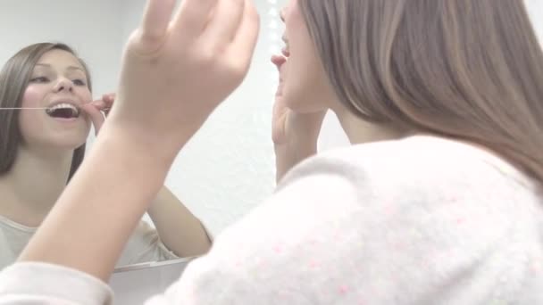 年轻漂亮的女孩使用牙线牙齿 — 图库视频影像