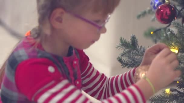 Little girl decorating Christmas tree — Stock Video