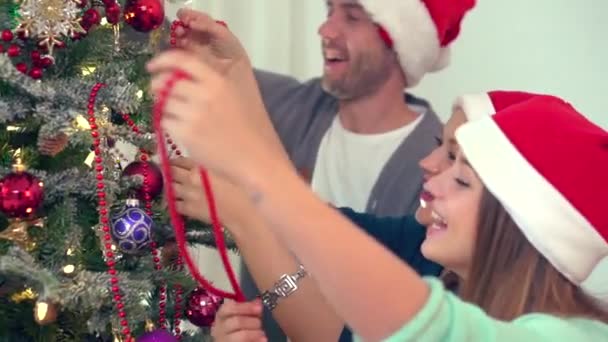 Familie schmückt Weihnachtsbaum — Stockvideo