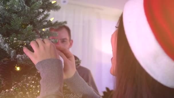 Pareja colgando bolas en árbol de Navidad — Vídeo de stock