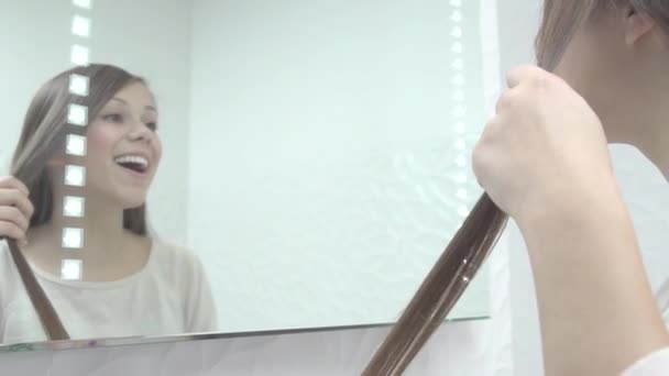 Mujer atractiva planchando su cabello — Vídeos de Stock