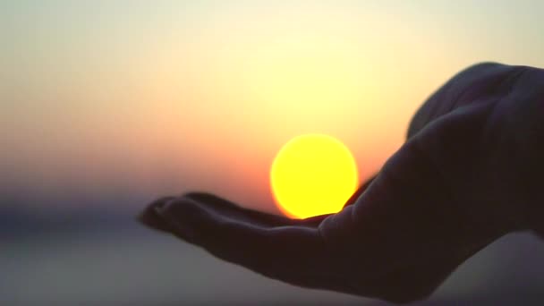 Hand nimmt eine Sonne gegen das Meer — Stockvideo