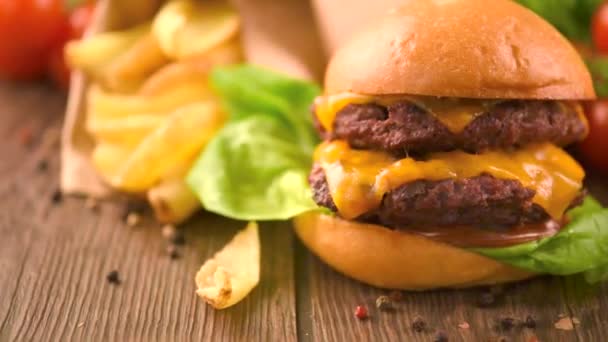 Hamburger s hranolky na dřevěný stůl — Stock video