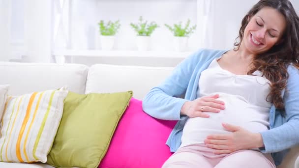 Pregnant woman resting on a sofa — Stock Video