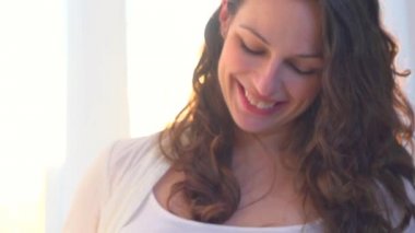 Hamile bir kadın karnını okşuyor.