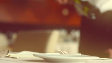 Garson bir şişe şarap açar.