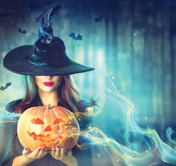 Halloween witch with a magic pumpkin — Stock Photo, Image