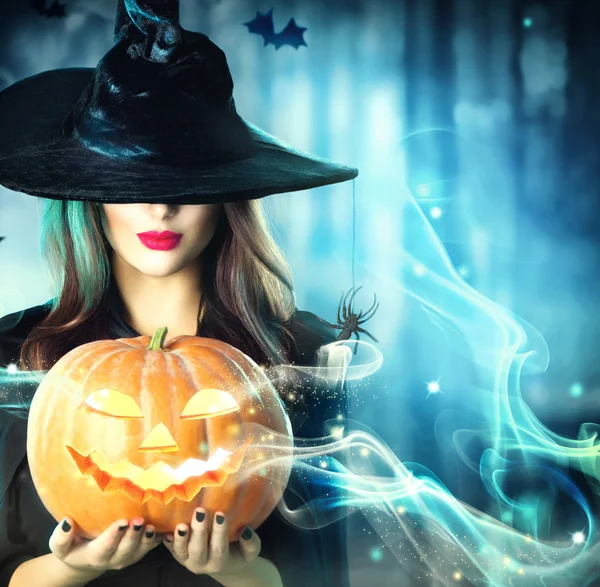 Bruxa de Halloween com uma abóbora mágica — Fotografia de Stock