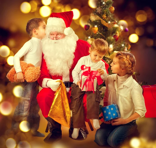 Weihnachtsmann beschenkt Kinder. — Stockfoto