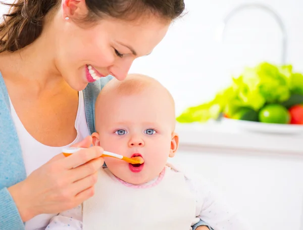 Mutter füttert ihr kleines Mädchen — Stockfoto