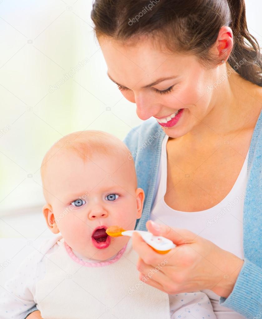 Mother feeding her baby girl.