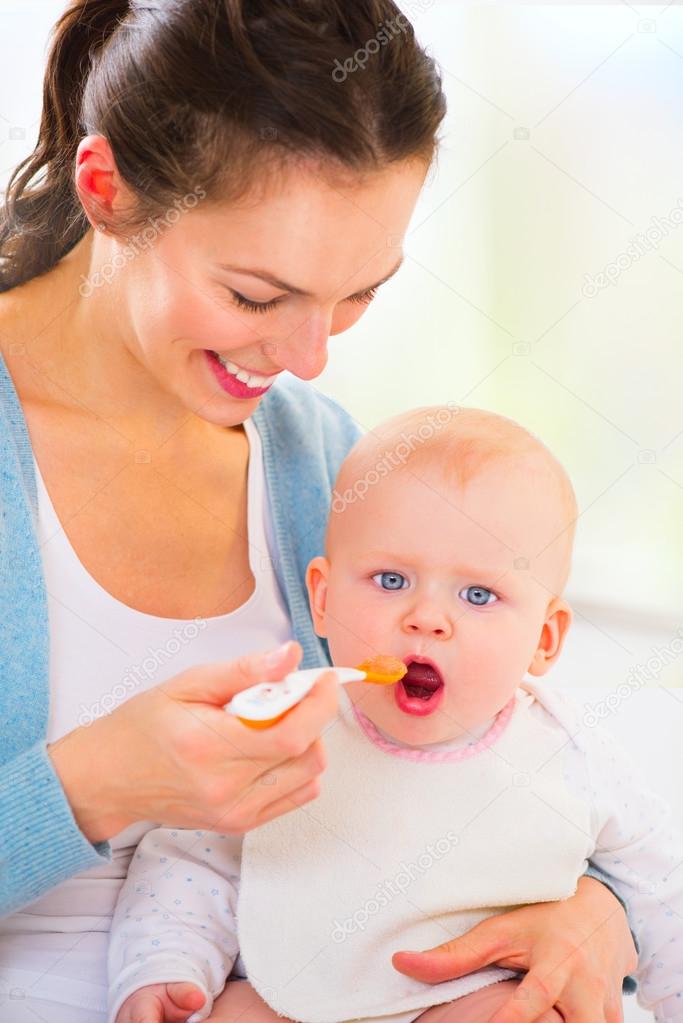 Mother feeding her baby girl.