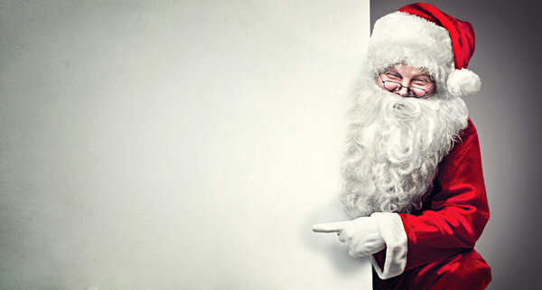 Санта Клаус указывает на пустой баннер
