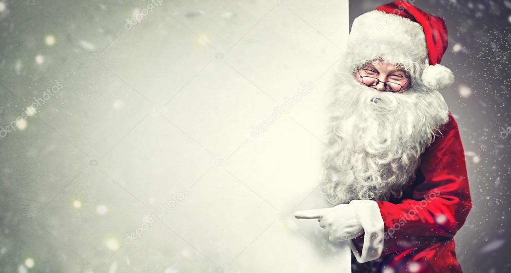 Santa Claus pointing on blank banner