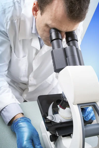 Científico mirando a través del microscopio en laboratorio —  Fotos de Stock