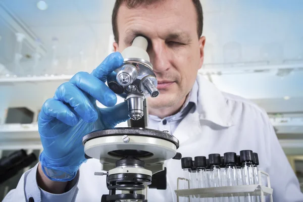 Cientista olhando através do microscópio em laboratório — Fotografia de Stock