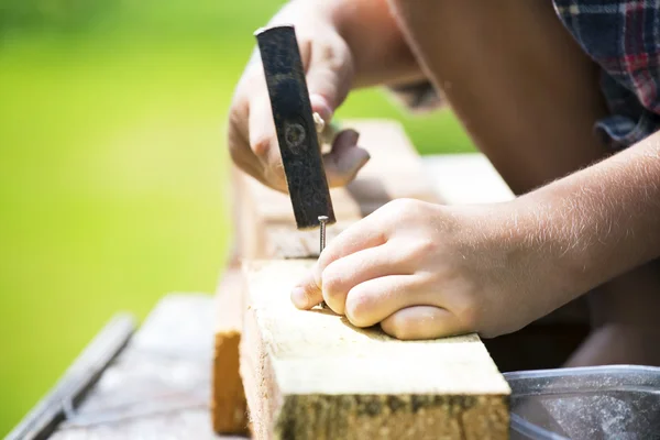 Pojke lär sig hammare spik — Stockfoto