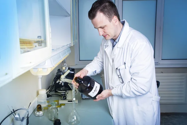 Mann hält Flasche mit schriftlicher Alkoholformel. — Stockfoto