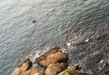 Dalgıçlar, kayalar ile tekne.