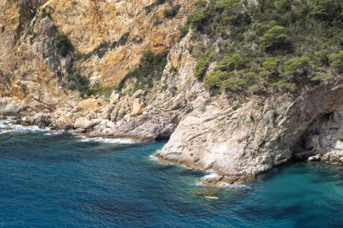 Kürekçiler kayalar ile tekne.