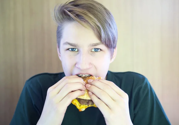 Boy eats hamburger — Stockfoto