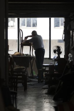 Adam bir sandalye onarır