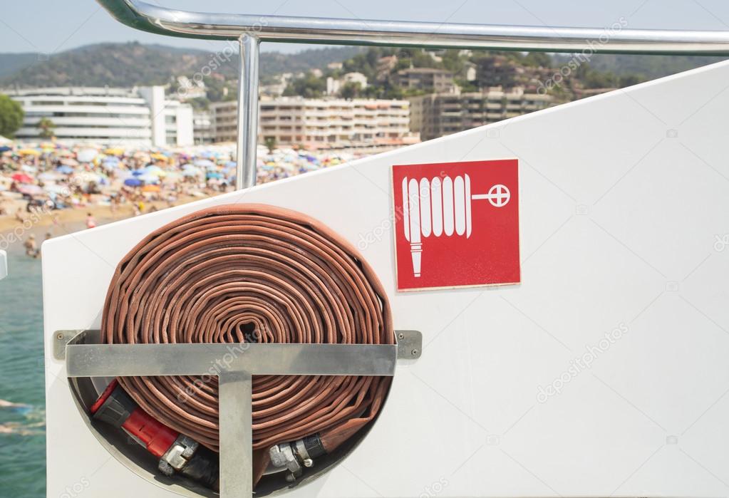 Fire hose and sign on board the boat.