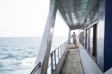 Güneşli bir günde bir geminin güvertesinde adam