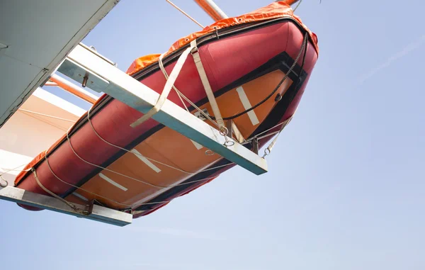 Bote salva-vidas laranja pendurado no navio no mar — Fotografia de Stock