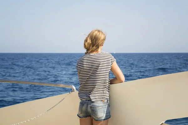 Tennager дивиться на бухту з колоди човна — стокове фото