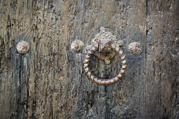 Rusty round metal ring on an old brown wooden gate — Stock Photo, Image