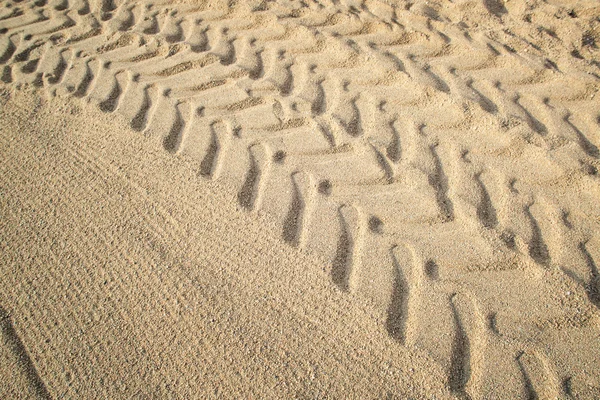 Huellas de neumáticos de tractor en arena de playa . — Foto de Stock