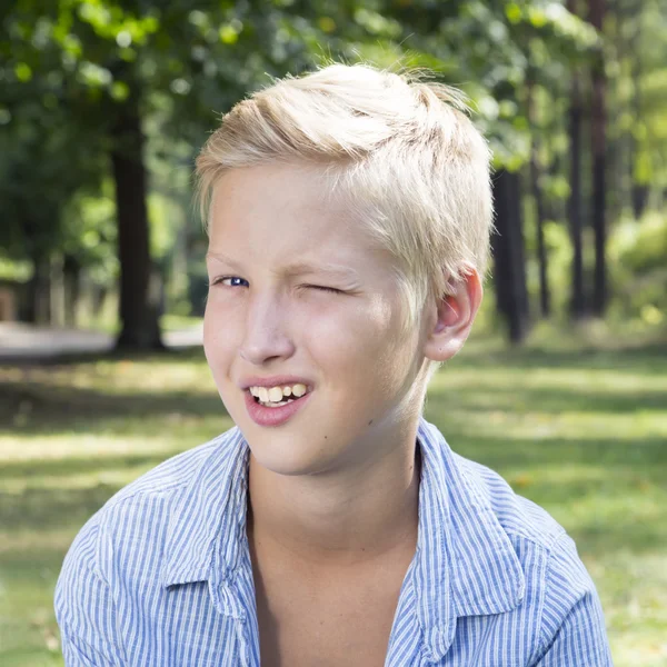 Ergens jongen zit op groen gras in bos. Concept van gelukkig gij Stockfoto