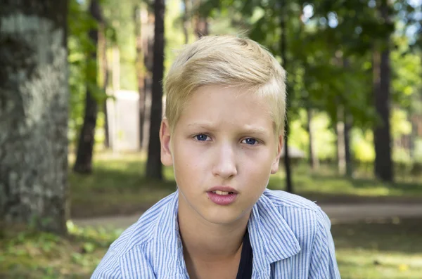 슬픈 소년 자연의 푸른 잔디에 앉아. — 스톡 사진