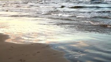 Baltık denizin dalgaları kumlu bir plaj üzerinde alınır.