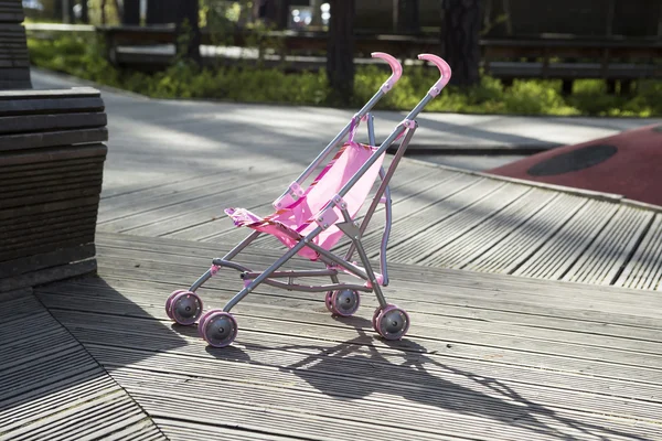 Розовая коляска стоит одна в парке . — стоковое фото