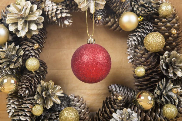 Couronne de Noël de cônes et de boules sur une surface en bois . — Photo