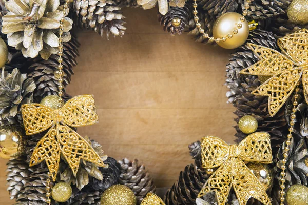 Corona de Navidad de conos y bolas en la superficie de madera . —  Fotos de Stock