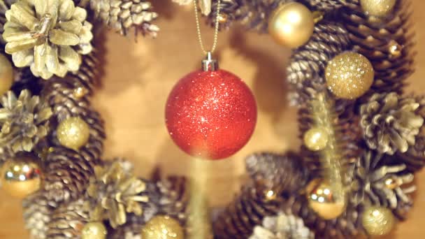 Couronne de Noël de cônes et de boules sur une surface en bois . — Video