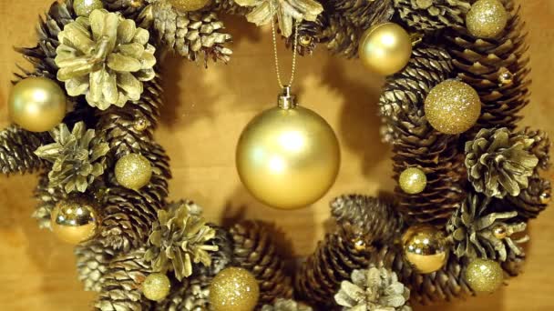 Corona de Navidad de conos y bolas en la superficie de madera . — Vídeos de Stock