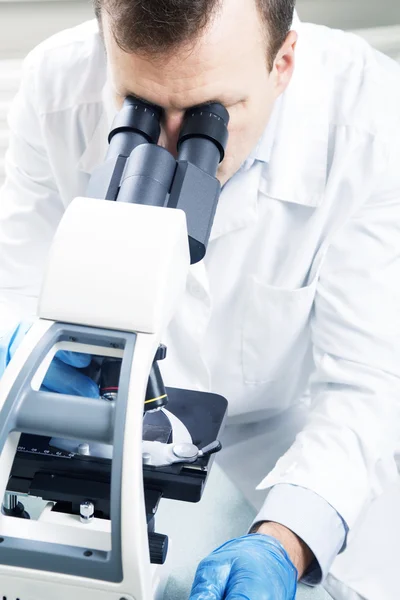 Científico mirando a través del microscopio en laboratorio —  Fotos de Stock