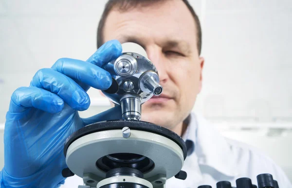 Cientista olhando através do microscópio em laboratório — Fotografia de Stock