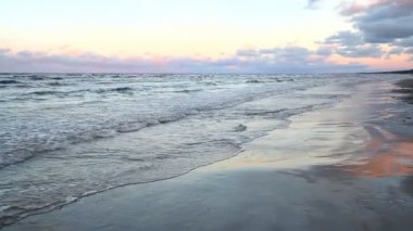 Baltık denizin dalgaları kumlu bir plaj üzerinde alınır.