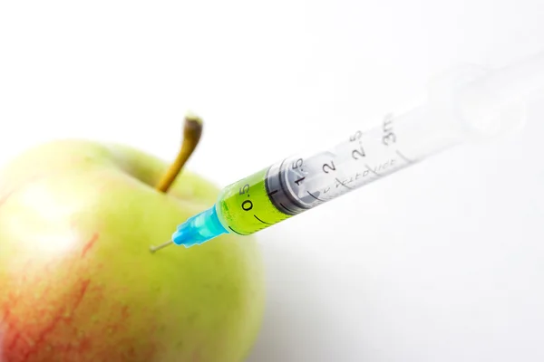 Syringe injecting poison in apple - Stock Image — Stock Photo, Image