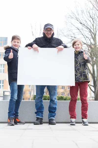 Happy friends showing white banner — Stock Photo, Image