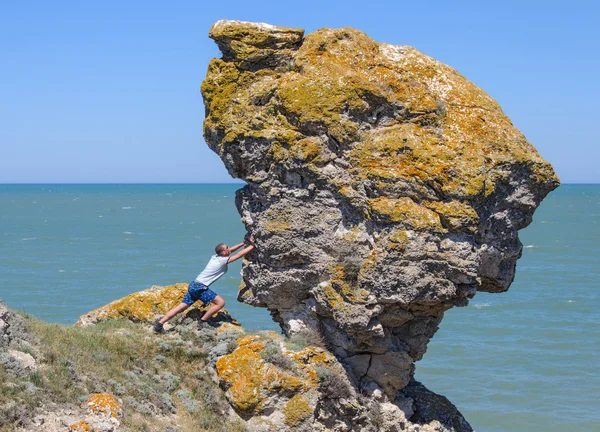 El hombre empujando una gran roca en el abismo —  Fotos de Stock